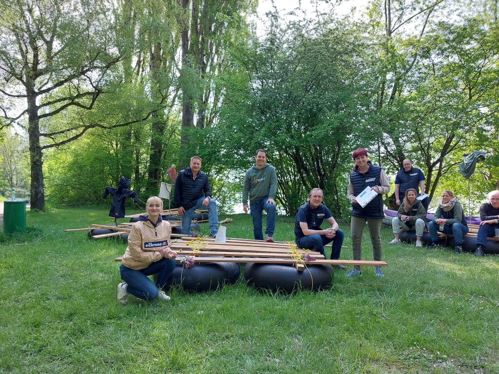 Team baut gemeinsam ein Floß am Bodensee.