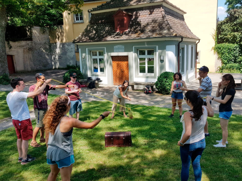 Gruppe löst Geocaching-Aufgabe im Grünen am Bodensee.