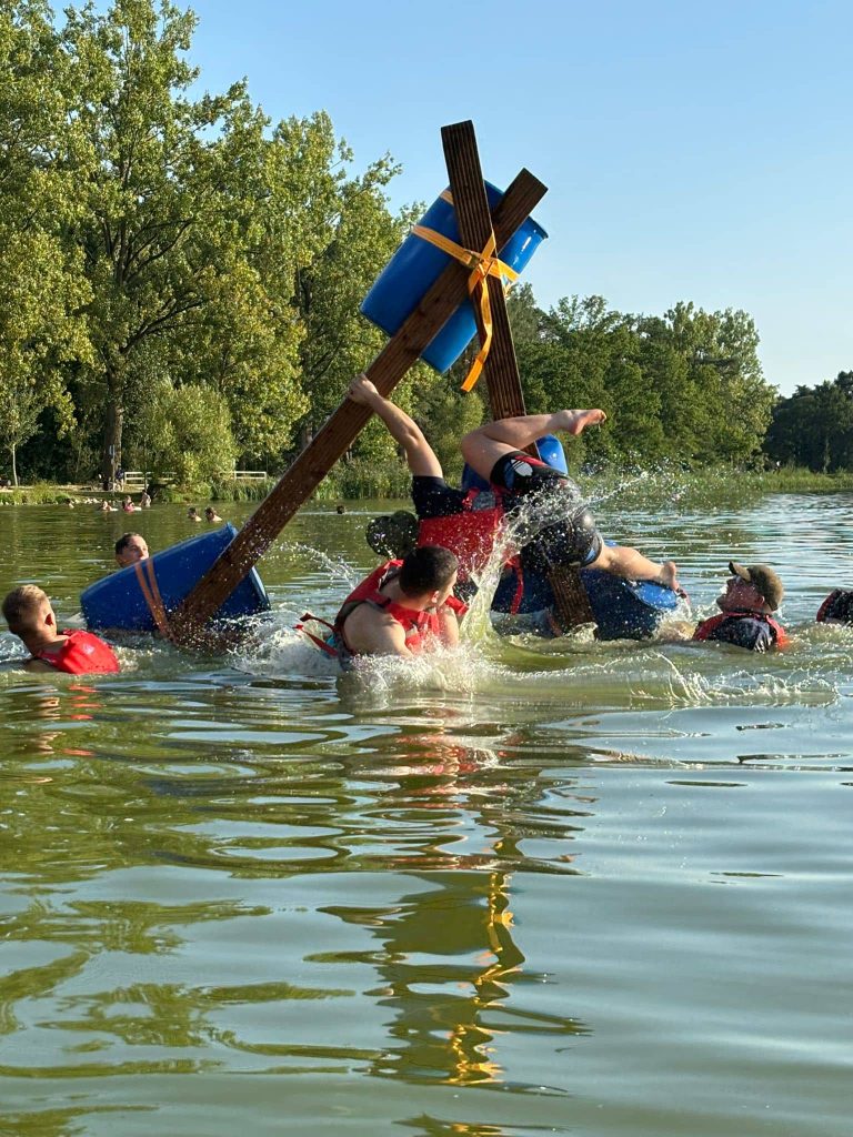 Gekentertes Floß beim Teamevent am Bodensee mit Teilnehmern im Wasser